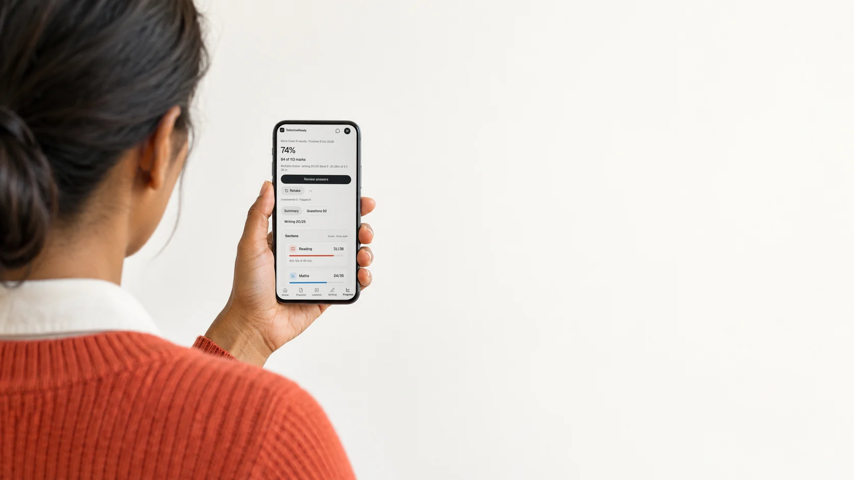 A parent, seen from behind, looking at one test's SelectiveReady results summary on a phone.